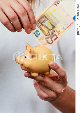 Male hands with banknote and piggybank Male hands with banknote and piggybank 21604108