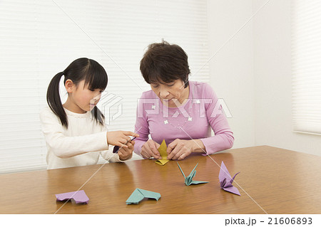 折り紙を折る孫と祖母 女の子 シニア 折り紙の写真素材
