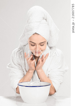 Young woman washing face with clean water Young woman washing face with clean water 21607785