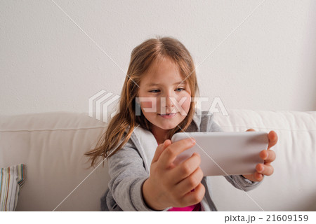Girl at home sitting on sofa, taking selfie Girl at home sitting on sofa, taking selfie 21609159