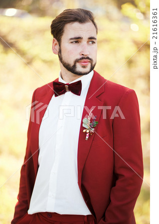 Portrait of the groom, red suit with a buttonhole 21616361