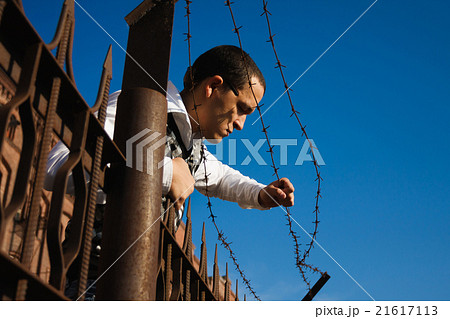 Man behind a barbed wire 21617113