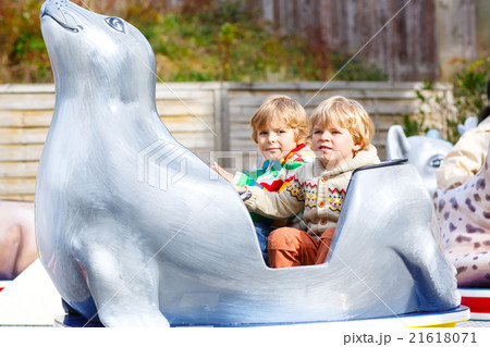 Two little kid boys on carousel in amusement park Two little kid boys on carousel in amusement park 21618071