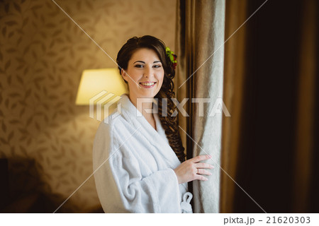 bride in a white lab coat standing near window 21620303
