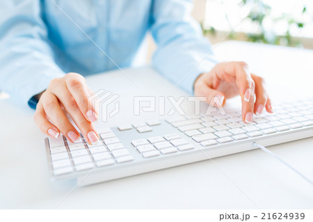 Woman office worker typing on the keyboard Woman office worker typing on the keyboard 21624939