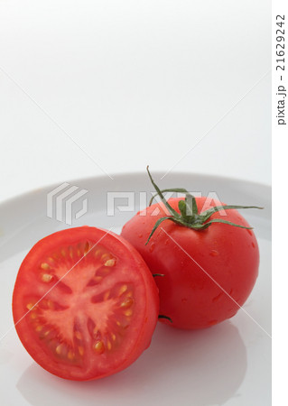 トマト一個半白い皿縦位置ハイアングル 21629242