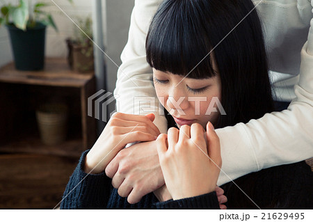 後ろから抱きしめられる女性の写真素材