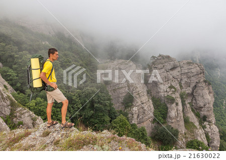 Hiker with backpacker in the foggy mountains 21630022