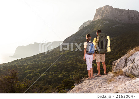 Couple looking at sunrise from mountain Couple looking at sunrise from mountain 21630047