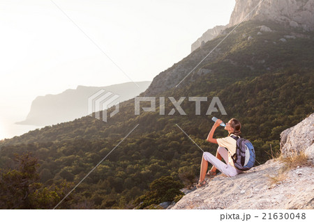 Woman drinks water on the mountain Woman drinks water on the mountain 21630048