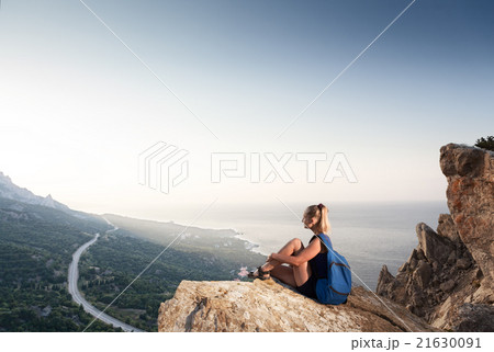 Girl looks at sunrise on the mountain 21630091