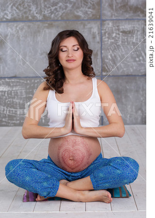 Pregnant girl with mehendi tattoo doing meditation 21639041