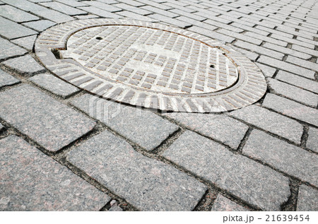 Round rusted hatch in urban cobblestone Round rusted hatch in urban cobblestone 21639454