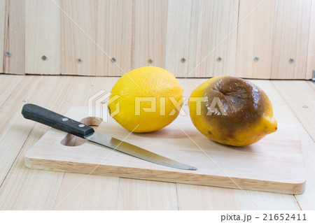 Fresh and rotten lemon put on chopping block 21652411