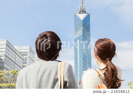 福岡タワーを見上げる男女 後ろ姿の写真素材