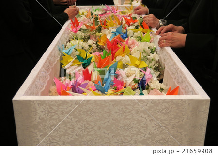 お別れに折鶴を入れる親族の写真素材
