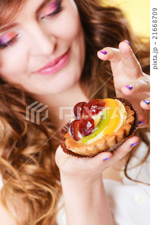 Closeup flirty woman eating fruit cake 21668709