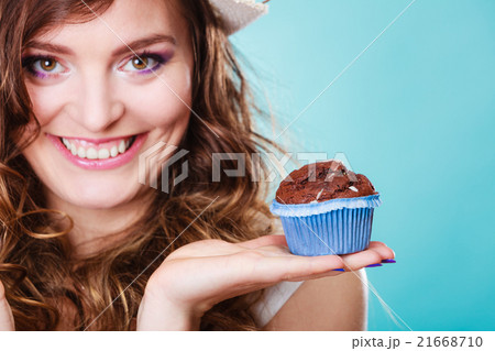 Smiling woman holds chocolate cake in hand Smiling woman holds chocolate cake in hand 21668710