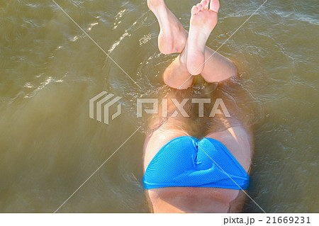 Backside view of young women lying in water, copy 21669231