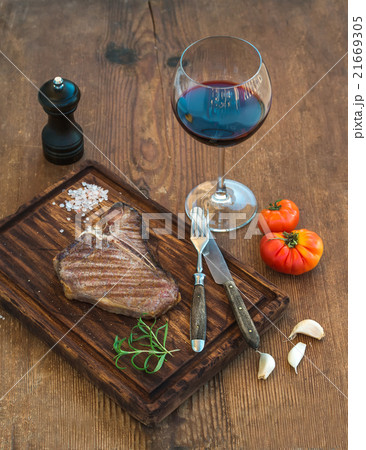 Cooked meat t-bone steak on serving board with 21669305