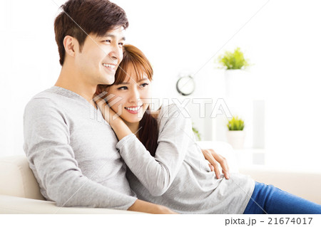 sweet young couple sitting in sofa 21674017