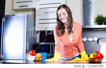 Attractive woman cleaning the counter in the kitchen Attractive woman cleaning the counter in the kitchen 21682499