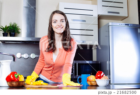 Attractive woman cleaning the counter in the kitchen Attractive woman cleaning the counter in the kitchen 21682500