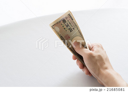 お札を握りしめるイメージの写真素材