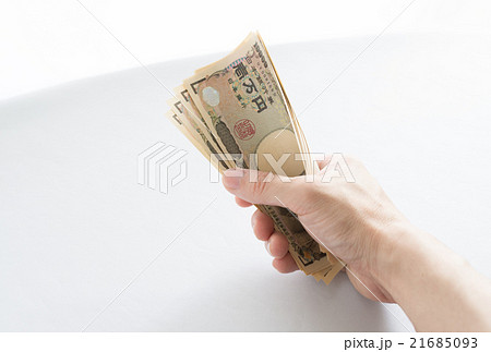 お札を握りしめるイメージの写真素材