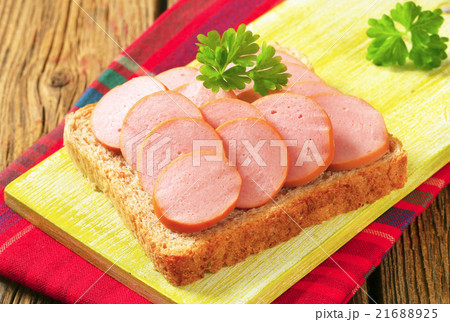 Whole wheat bread with sliced sausage 21688925
