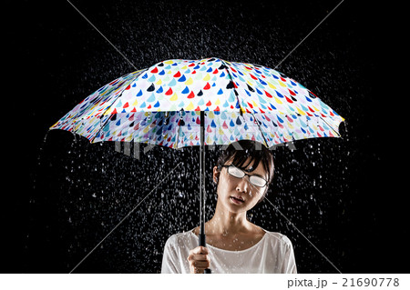 雨傘をさす女性 メガネが曇るの写真素材
