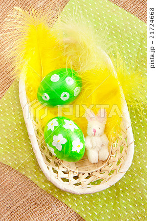 Easter eggs in a basket with yellow feathers Easter eggs in a basket with yellow feathers 21724668
