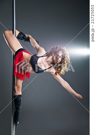 Young slim pole dance woman exercising over dark Young slim pole dance woman exercising over dark 21725055
