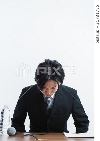 記者会見で頭を下げる男性 21731755