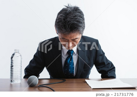 記者会見で頭を下げる男性 21731776