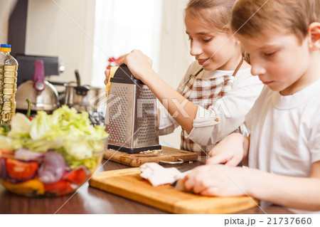 Small boy with his sister preparing food together Small boy with his sister preparing food together 21737660