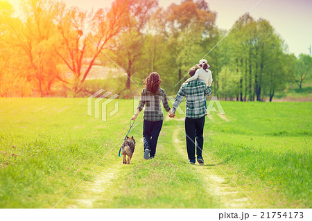 Happy family with dog walking on the country road Happy family with dog walking on the country road 21754173
