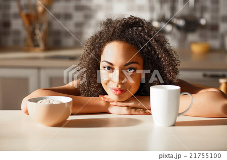 Nice pleasant girl sitting at the table Nice pleasant girl sitting at the table 21755100