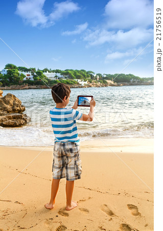 The young man traveler photographing sea The young man traveler photographing sea 21756519