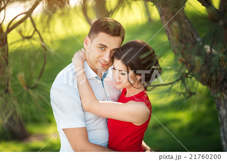 Happy young couple embrace in park Happy young couple embrace in park 21760200