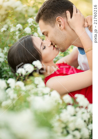 Happy young couple kissing in park Happy young couple kissing in park 21760216