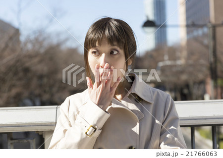 女性 表情 驚く 外 手を口に当てるの写真素材