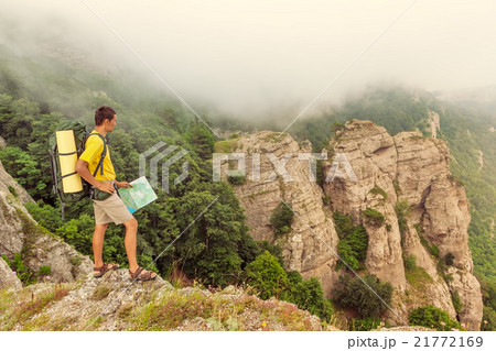 Backpacker with a map on the mountains Backpacker with a map on the mountains 21772169