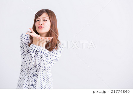 パジャマで投げキッスをする女性の写真素材