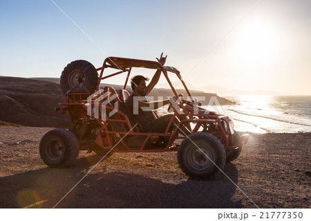 Man driving quadbike in sunset. Man driving quadbike in sunset. 21777350