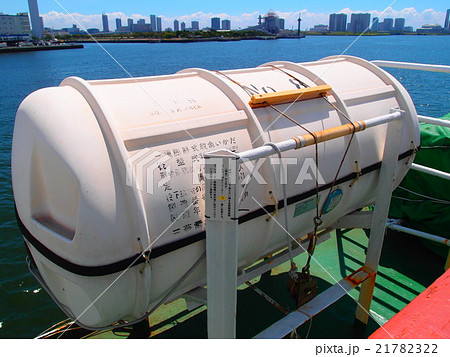 おがさわら丸の救命いかだの入った容器と東京 竹芝桟橋の対岸のビル群の写真素材
