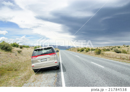 Car at Side of Road Leading to Snow Mountains 21784538