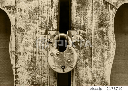 closed old metal lock hanging on wooden door  21787104