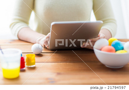 close up of woman with tablet pc and easter eggs close up of woman with tablet pc and easter eggs 21794597