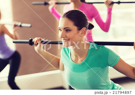 group of people exercising with bars in gym 21794897